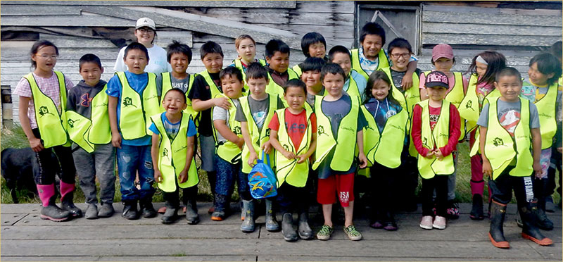Group photo of kids in bright green vests